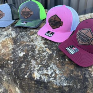 Four colorful hats on a large rock.